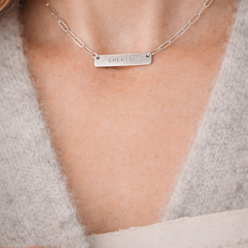 Silver necklace with a personalized hand stamped word that says CHERISH by CITRUS