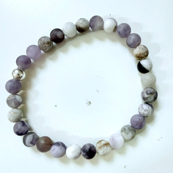 Beaded bracelet with gray, white, and purple beads on a white background
