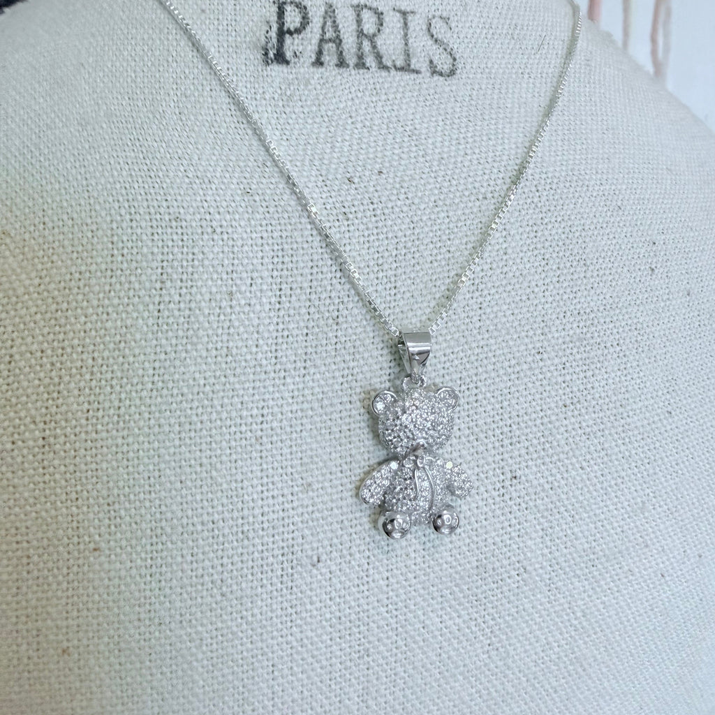 Necklace with a teddy bear pendant on a mannequin labeled 'PARIS'.