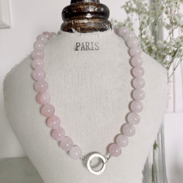 Necklace with pink beads on a mannequin bust labeled 'Paris'.