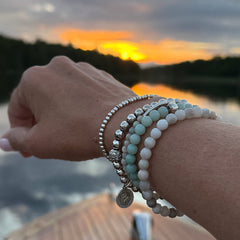 Close-up of a wrist wearing gemstone bracelets by CITRUS