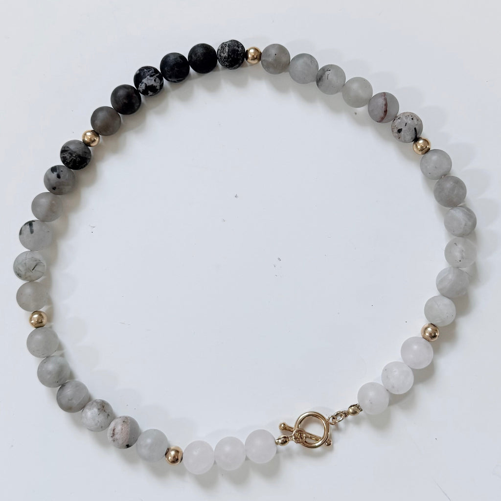 Tourmaline Beaded Necklace with gray and black beads and a gold toggle claso
